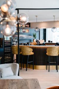 un bar dans un restaurant avec des chaises et un comptoir dans l'établissement Hotel du Bassin, à Ostende