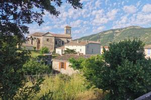 un pequeño pueblo con una iglesia a lo lejos en Gîte moderne en Drôme en Roche-Saint-Secret