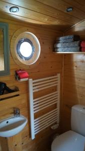 een badkamer met een wastafel, een toilet en een raam bij La Girardière in Le Boupère