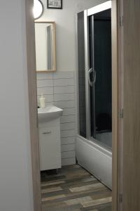 a bathroom with a sink and a tub and a toilet at Apartmán Doupě in Humpolec