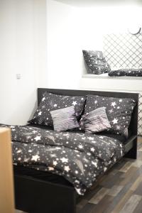 a black couch with black and white pillows on it at Apartmán Doupě in Humpolec