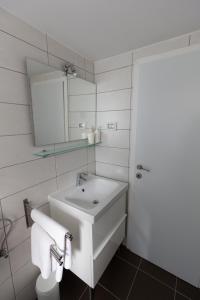 een witte badkamer met een wastafel en een spiegel bij Downtown Apartments Pula in Pula