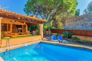 Villa Ciutada في بوينسا: مسبح ذو كرسيين ازرق بجوار منزل
