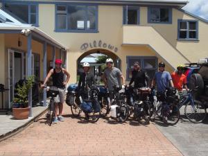 a group of people standing in front of a building with their bikes at Orewa Pillows Lodge in Orewa