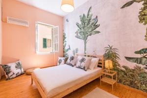 a bedroom with a bed and a wall with plants at Casa Tropicana in Corfu