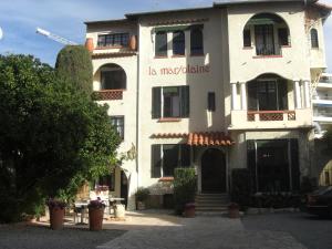 a white building with a sign on the side of it at La Marjolaine in Juan-les-Pins