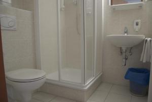 a bathroom with a shower and a toilet and a sink at Hotel Alser in Vienna