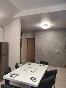 una sala de reuniones con mesa blanca y sillas en Apartament Ozon Poiana Brasov, en Poiana Brasov