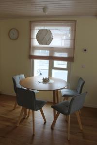 a table and chairs in a room with a clock at Ryytlihaus Old Town Apartement in Haapsalu +15 photos