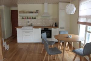 a kitchen with a wooden table and chairs at Ryytlihaus Old Town Apartement in Haapsalu