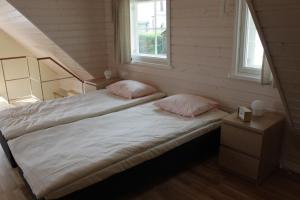 a bedroom with two beds and two windows at Ryytlihaus Old Town Apartement in Haapsalu