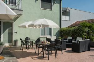 a patio with a table and chairs and an umbrella at Relais Corte Bergamini in Peschiera del Garda