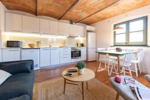 cocina y sala de estar con sofá y mesa en Bravissimo Raïms Penthouse en Girona
