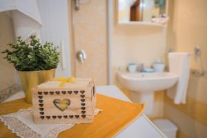 een badkamer met een houten doos met een hart erop bij CASA ENZO con vista mare in Amalfi