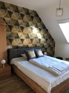 1 dormitorio con 1 cama grande y pared geométrica en Székely Fogadó, en Tunyogmatolcs
