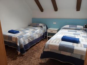 2 camas en una habitación de color azul y blanco en Albergue Borda Nadal, en Ansó