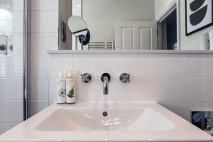um lavatório branco na casa de banho com um espelho em Beautiful, modern apartment in Hope Place Bath, 1 Bedroom Luxury City Centre Apartment with Beautiful City Views, a stones throw from The Royal Crescent in Bath em Bath
