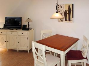 a dining room with a table and a tv at Apartment am Haferland by Interhome in Wieck