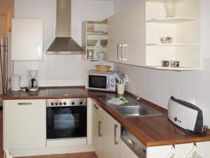 a kitchen with a sink and a microwave at Apartment am Haferland by Interhome in Wieck