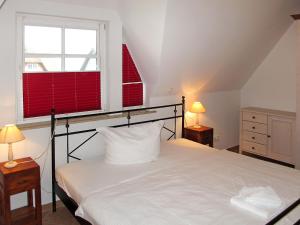 ヴィークにあるApartment am Haferland by Interhomeのベッドルーム1室(ベッド1台、赤いシャッター付きの窓付)
