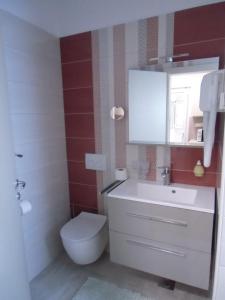 a bathroom with a white sink and a toilet at Apartments Romano in Rovinj