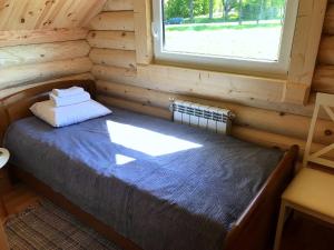 a bedroom with a bed in a log cabin at Kurna Saunaküla in Kurna