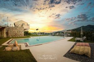 a swimming pool with a sunset in the background at Agriturismo Terre degli Angeli in Pietra Ligure