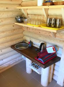 a wooden kitchen with a sink and a counter at Kurna Saunaküla in Kurna