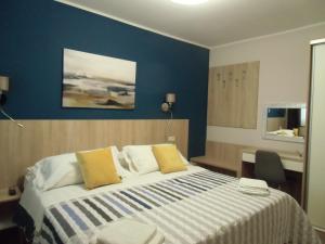 1 dormitorio con 1 cama grande y pared azul en Apartments Romano, en Rovinj