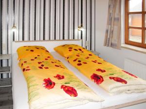 ブレーゲにあるApartment Zeit zum Träumen I by Interhomeの赤い花が飾られたベッドの上に枕2つ