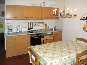 a kitchen with wooden cabinets and a table with a table cloth at Apartment Rosengang-ALK by Interhome in Born