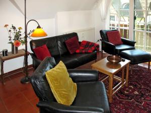 ボルンにあるApartment Rosengang-ALK by Interhomeのリビングルーム(黒い革張りのソファ、椅子2脚付)