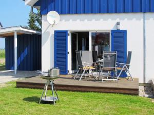 a deck with chairs and a table in a yard at Holiday Home Achterblick 2 by Interhome in Altefähr