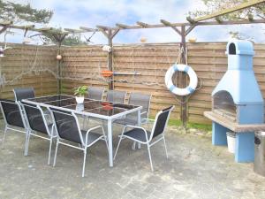 a patio with a table and chairs and a grill at Holiday Home Ostwind by Interhome in Ummanz