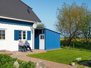 2 personnes assises sur une chaise à l'extérieur d'une maison dans l'établissement Holiday Home Strelasund by Interhome, à Altefähr