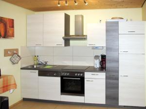 una cucina con mobili bianchi e un forno a piano cottura di Holiday Home Strelasund by Interhome ad Altefähr Altre 25 foto