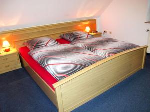 WiardenにあるHoliday Home Ferienhaus Meerのベッドルーム1室(大型木製ベッド1台、枕2つ付)