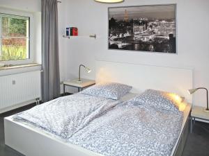 ein Schlafzimmer mit einem Bett und zwei Tischen mit Lampen in der Unterkunft Holiday Home Am Walde by Interhome in Lubmin