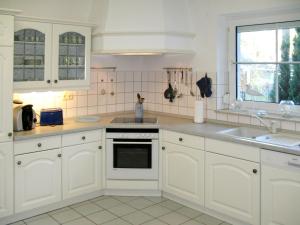 a kitchen with white cabinets and a sink at Holiday Home Am Walde by Interhome in Lubmin