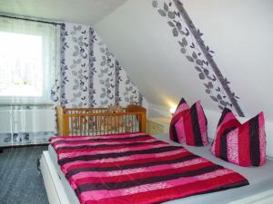 a bedroom with a bed with pink and black pillows at Apartment Mary by Interhome in Karlsburg