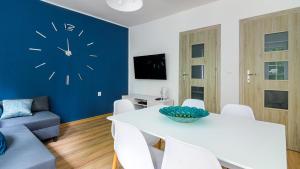 salon z białym stołem i zegarem na ścianie w obiekcie Baltic Capital - BillBerry Apartments w Gdańsku