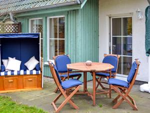 ツィノヴィッツにあるHoliday Home Im Kiefernweg by Interhomeの木製テーブルと椅子付きのパティオ