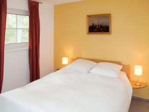 ツィノヴィッツにあるHoliday Home Im Kiefernweg by Interhomeのベッドルーム(白いベッド1台、窓付)