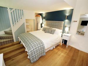 a bedroom with a white bed with a blue wall at Blas Gwyr in Llangennith