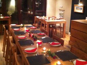 a long wooden table with red and white dishes on it at Blas Gwyr in Llangennith