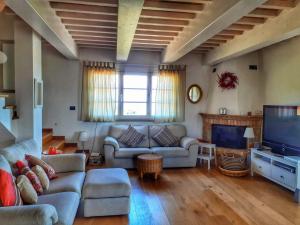 a living room with a couch and a tv at Dimora Degli Angeli in Chianni