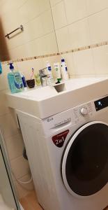 a washing machine in a bathroom with a sink at Palanga-Smilgu. g. in Palanga +2 photos