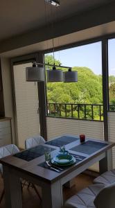a dining room table with a view of a green hill at Palanga-Smilgu. g. in Palanga