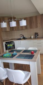 a kitchen with a table with white chairs and a counter at Palanga-Smilgu. g. in Palanga