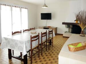 comedor con mesa, sillas y TV en Holiday Home Le Maupas by Interhome, en La Tranche-sur-Mer